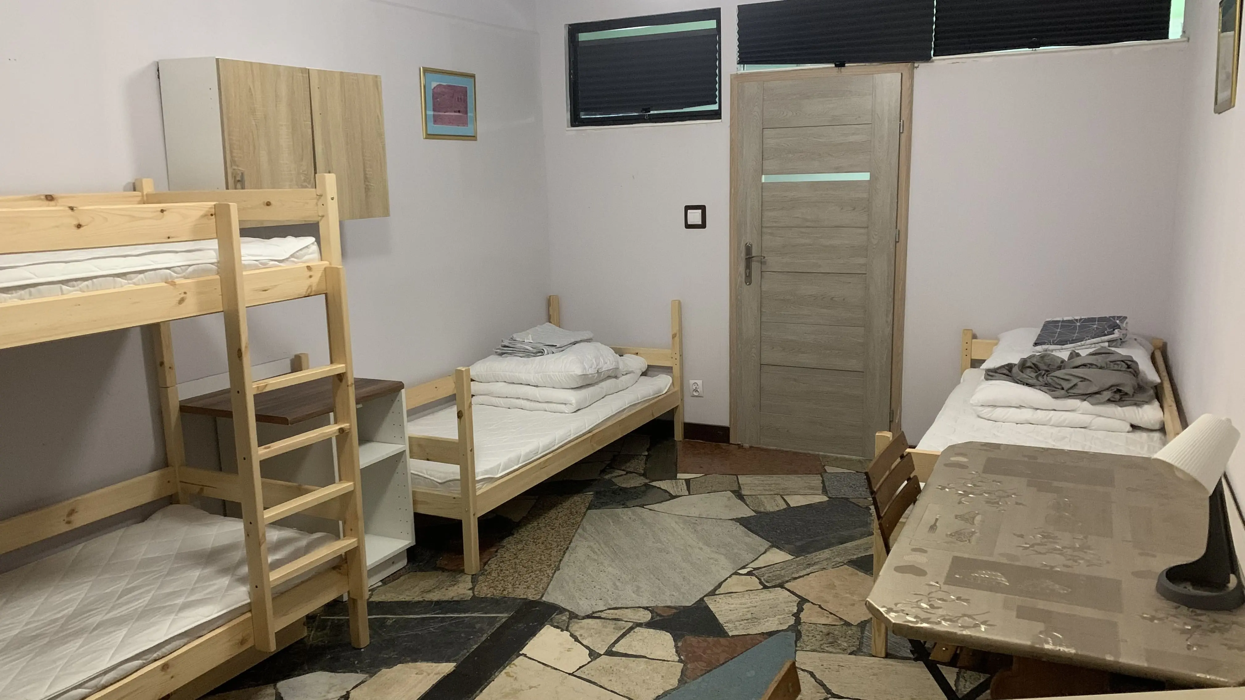 Kwatera pracownicza na parterze nr 1 - widok na łóżka i przestrzeń do przechowywania.