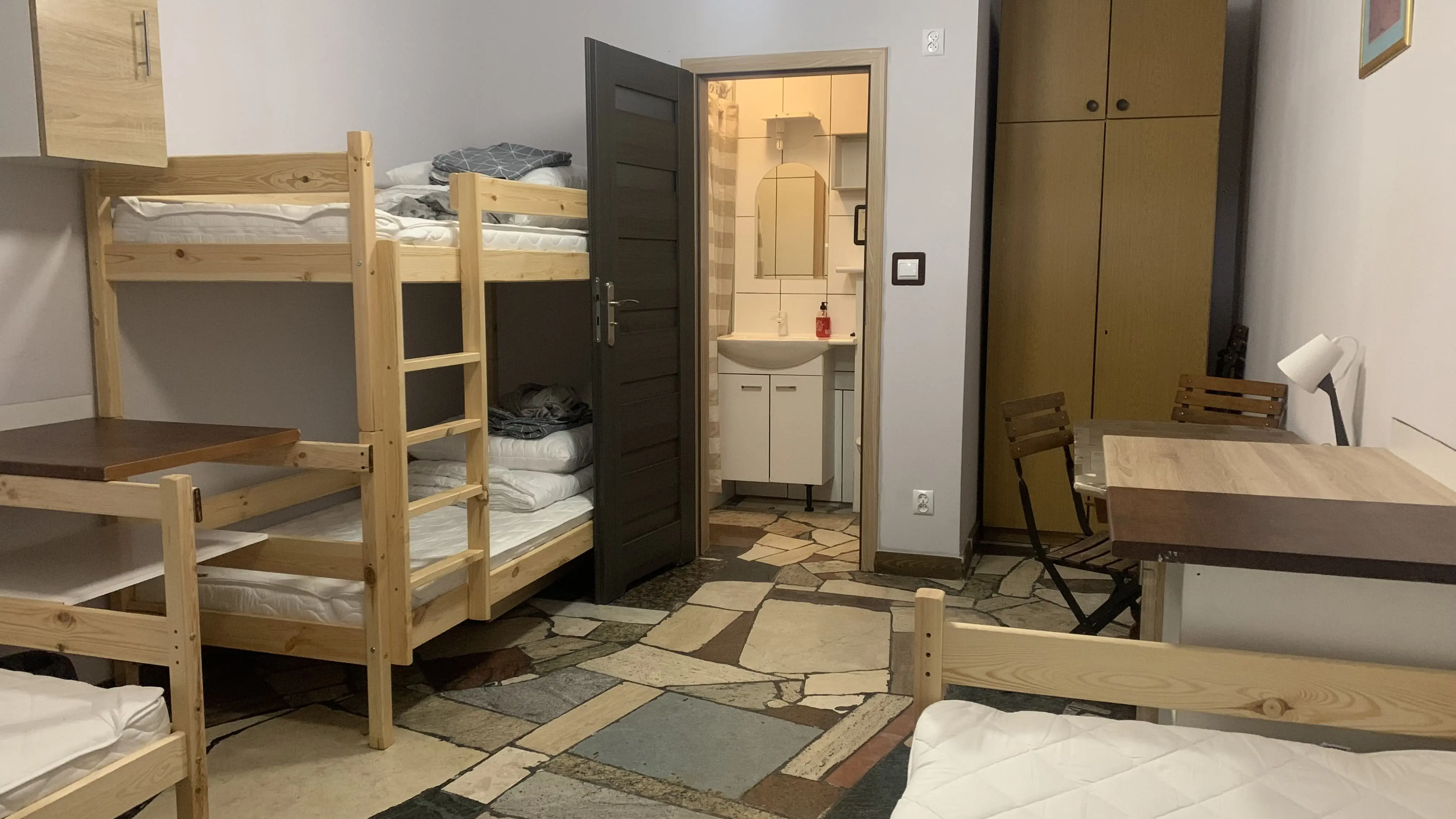 Pokój pracowniczy z dwoma pojedynczymi łóżkami i jednym piętrowym z własną łazienką. Funkcjonalna przestrzeń w spokojnej okolicy.