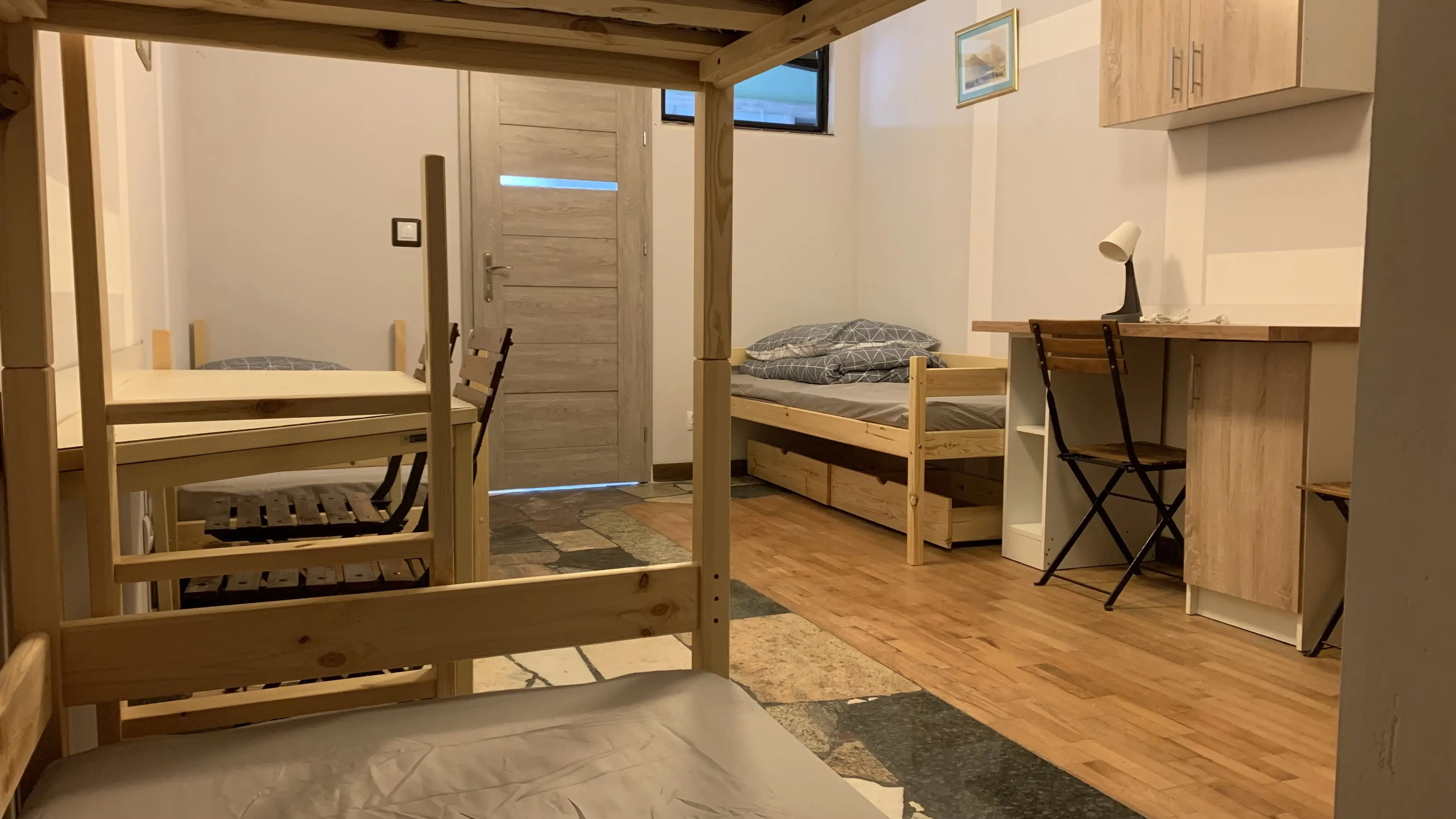 Kwatera pracownicza na parterze nr 4 - widok na łóżka i przestrzeń do relaksu.