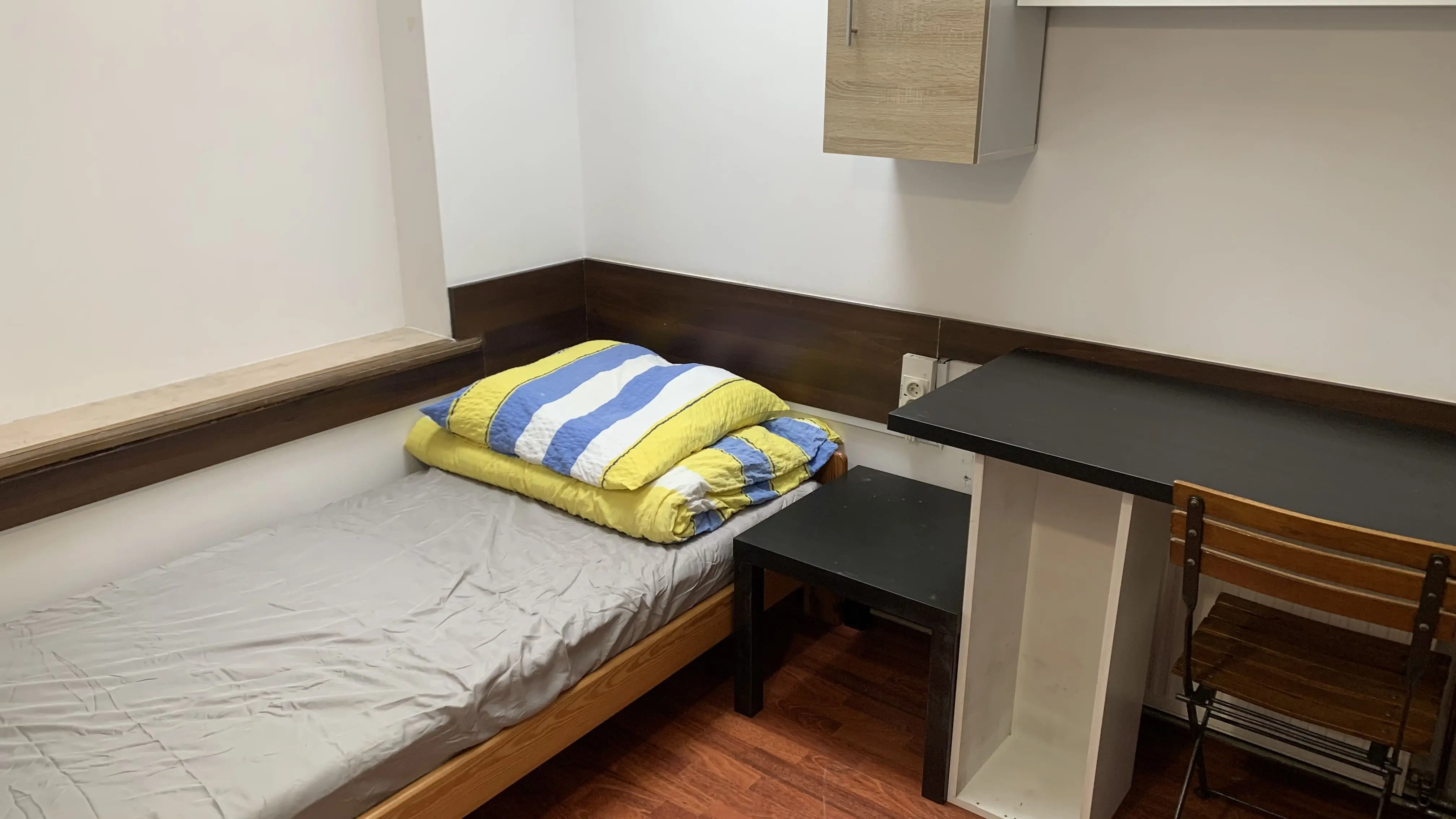 Pokój z aneksem kuchennym, wyposażony w wygodne łóżka i strefę do spożywania posiłków. Idealne rozwiązanie dla dłuższych pobytów.